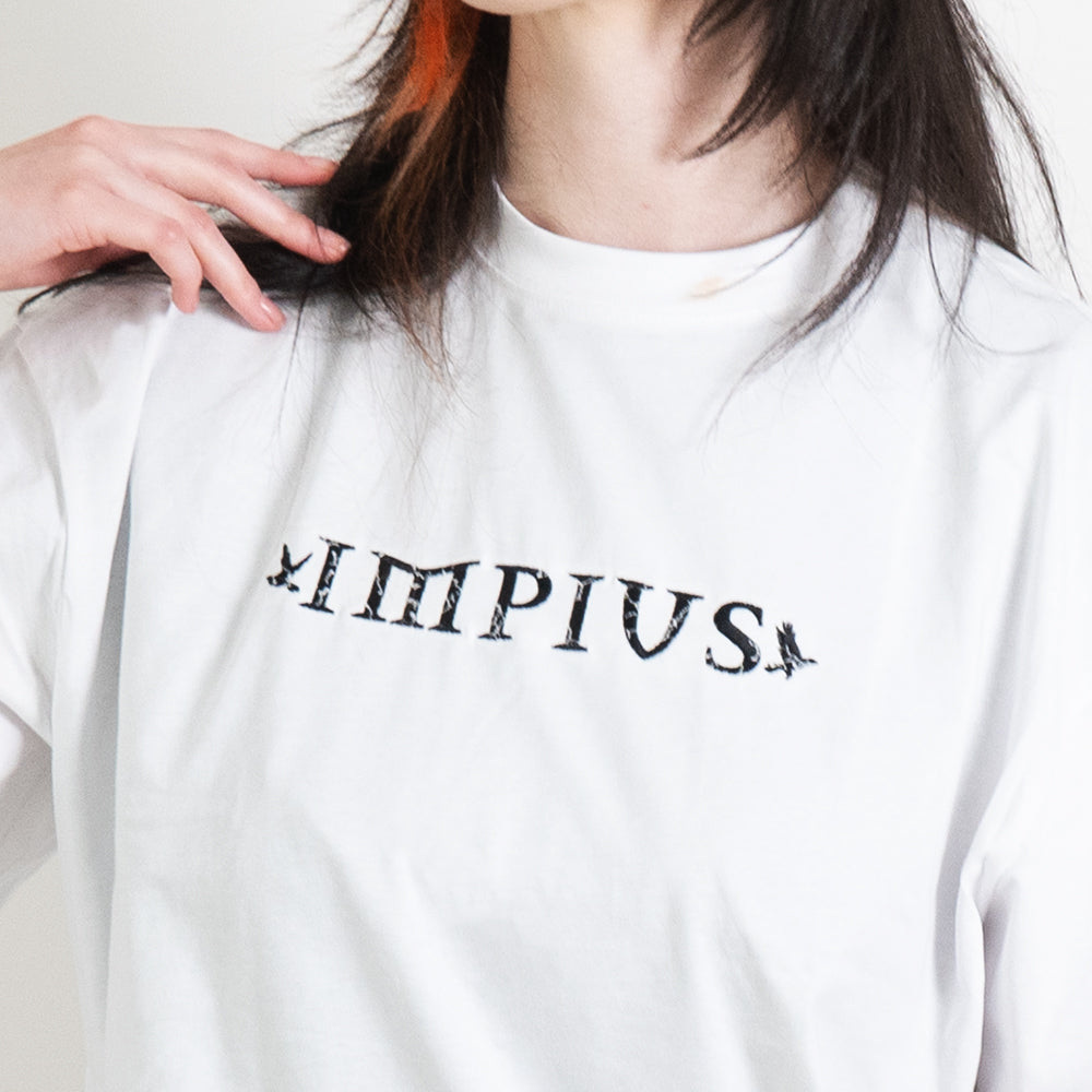 A close up image of the impius logo on a white oversized tee