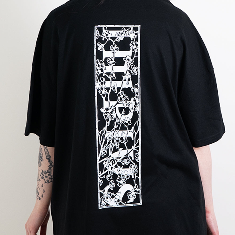 A close up shot of the impius cherry blossom back design on a black oversized tee