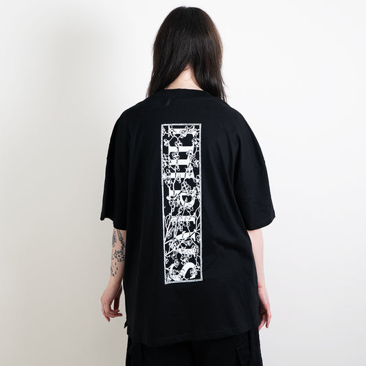 Alternative model wearing a black oversized tee with the impius cherry blossom back design