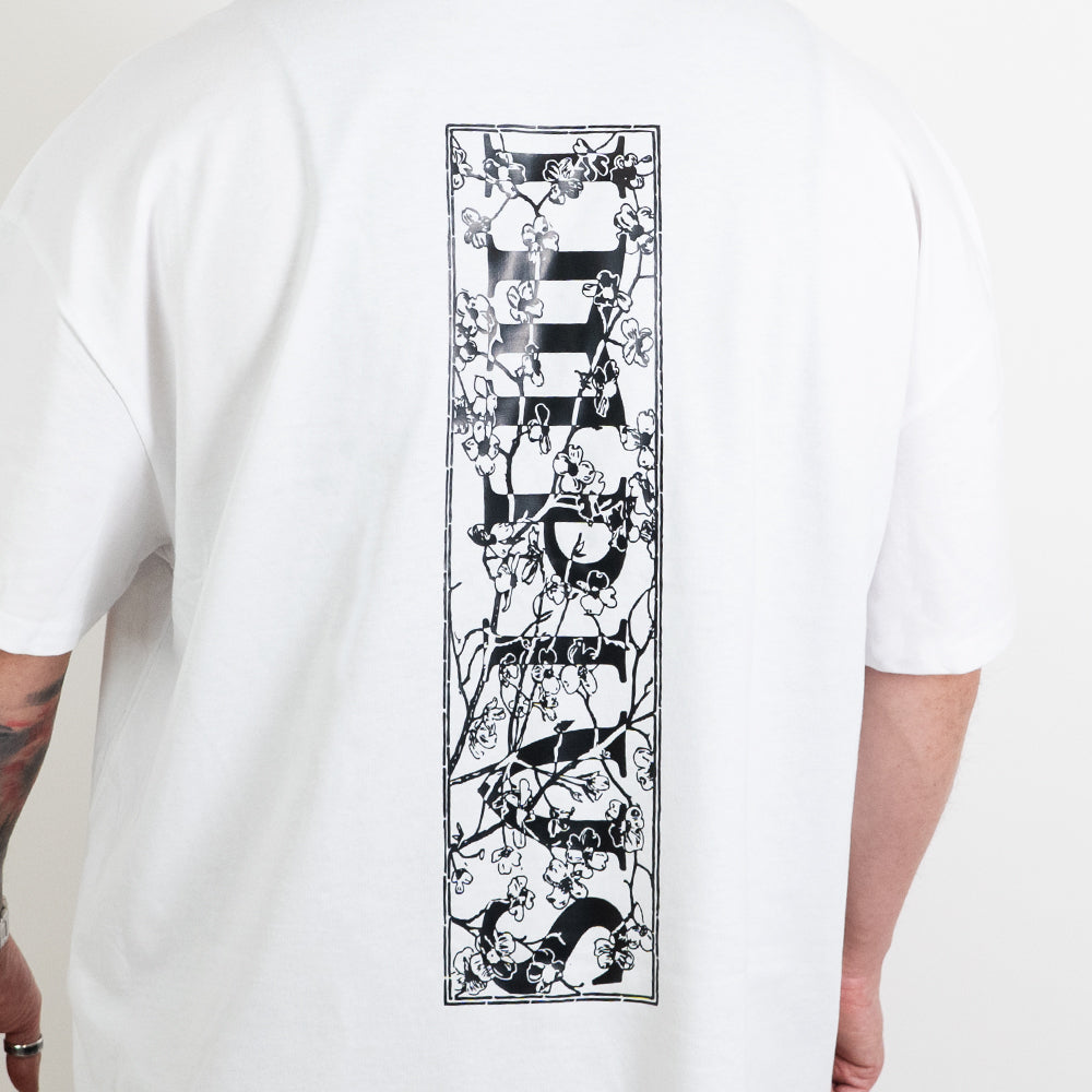A close up shot of the impius cherry blossom back design on a white oversized tee