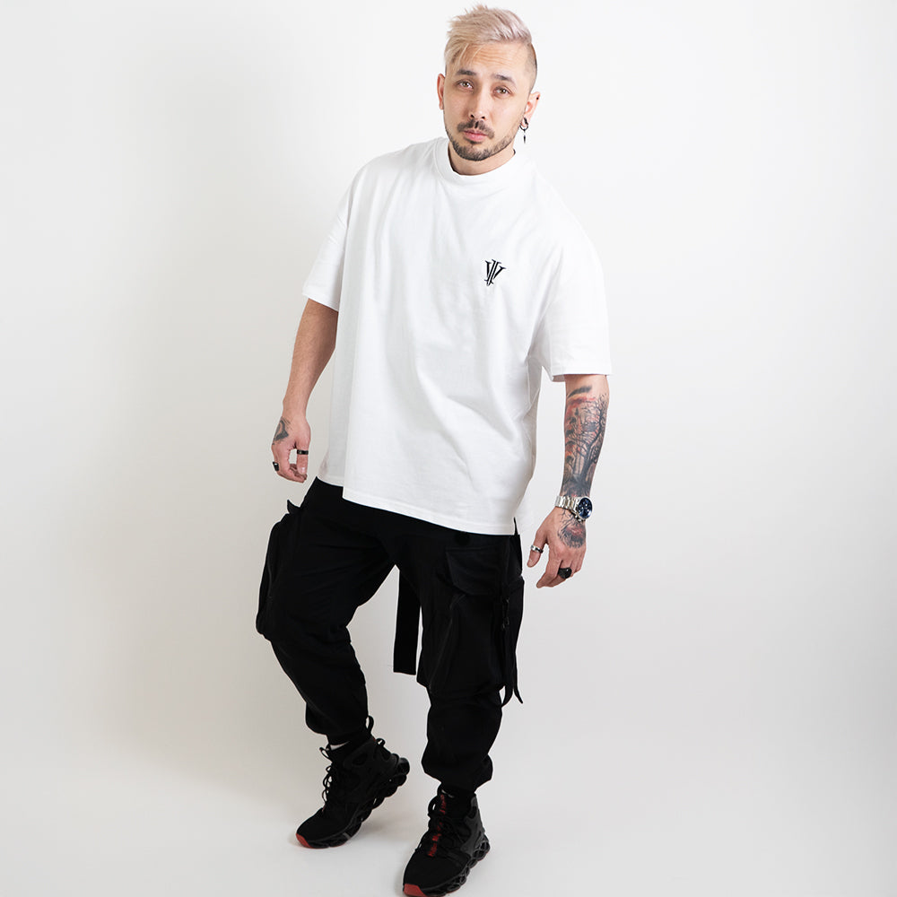 A full body image of an alternative model wearing a white oversized tee with the impius logo