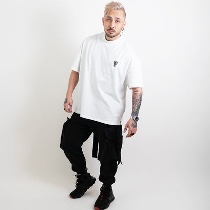 A full body image of an alternative model wearing a white oversized tee with the impius logo