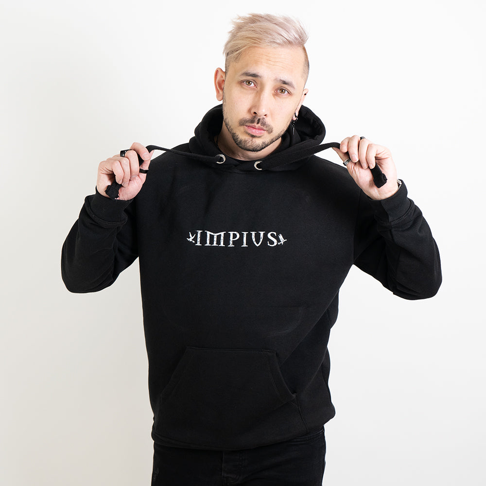 Alternative model wearing a black hoodie with the Impius logo
