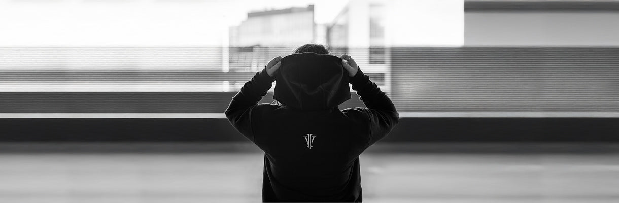 Alternative woman holding up her hood showing the Impius logo on a hoodie