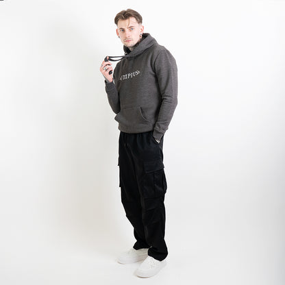 A full body image of a tattooed model wearing a grey hoodie with the Impius logo