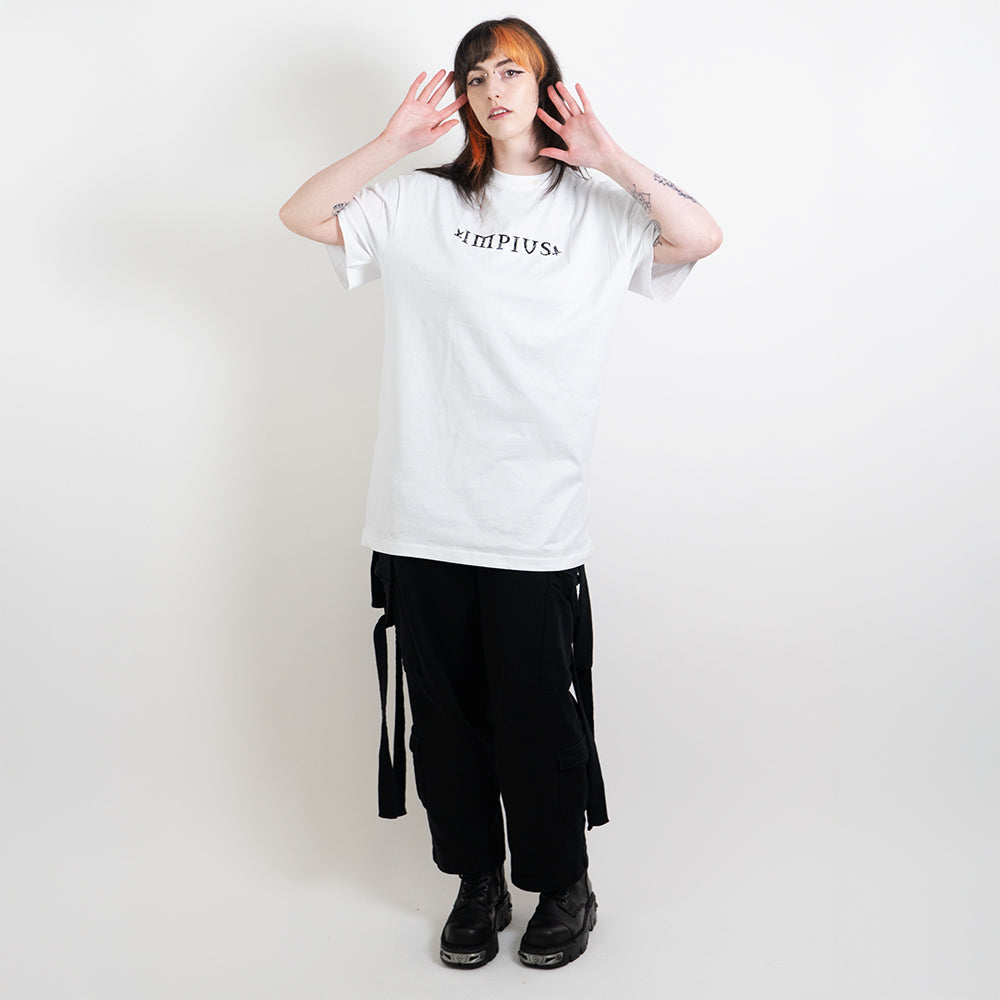 A full body image of an alternative model wearing a white oversized tee with the impius logo