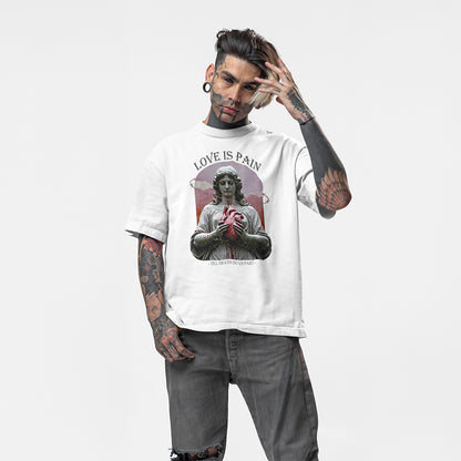 A full body image of a tattooed model wearing a white oversized tee with the impius love is pain design